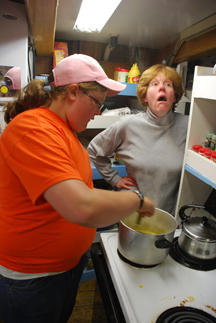 Mrs. Mahigian is agog as Casey helps prepare and serve pancakes with orange sauce.