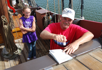 Captain Reynolds stamps Emily's Crew Rating Log.