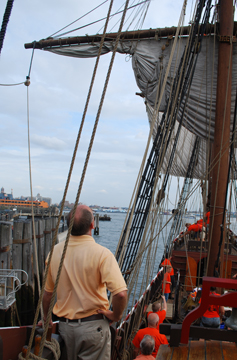 The crew sets the main course to sail off the dock at Battery Park.