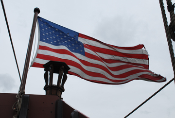 The American flag flaps in a strong wind.
