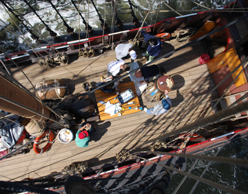 Captain Reynolds and several students pore over a chart of the Sound.