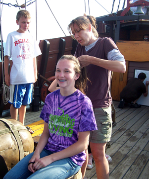 Ms. Johnsen puts Ms. Reynolds' hair in a French braid.