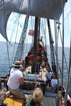 Alex works on bracing the fore top while the main mast team works in the background.