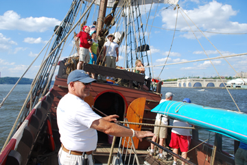 The ship heels sharply as happy crew look on.