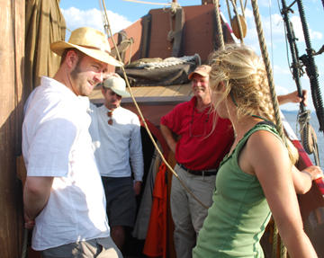 Marco, Corey, Captain Reynolds, and Swantje chat outside the captain's cabin.