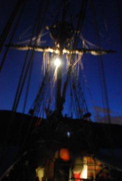 The anchor light shines from just below the fore course yard.