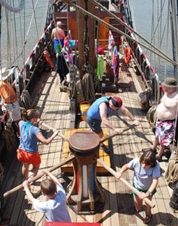An animated sequence of the full weather deck, with crew walking the capstan in the foreground.