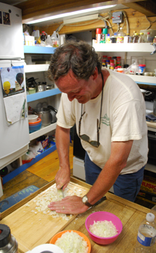 Steve dices onions in the galley.