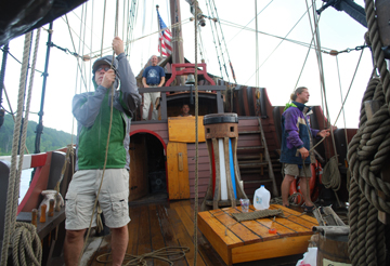 The crew man their posts during a brief downpour.