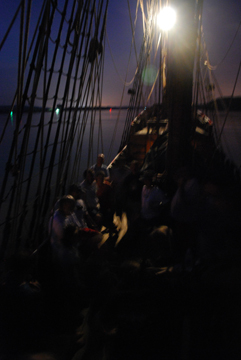 The crew sings on the weather deck, illuminated only by the anchor light and the stars.