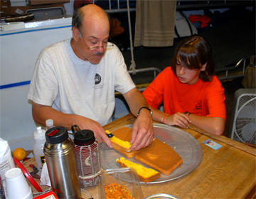Jack and Evi create a ship-shaped birthday cake in stages.