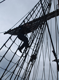 Mr. Berg climbs the main mast rigging.