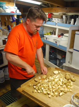 Mr. Wolfe dices potatoes for dinner.