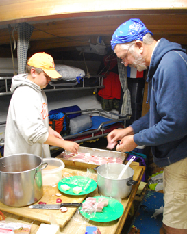 Colton and Mr. McLaughlin prepare dinner in the galley.
