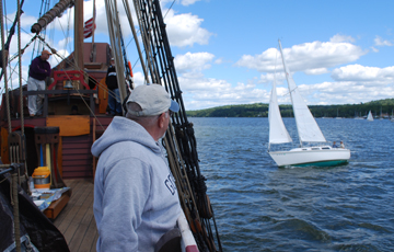Mr. Van Aken watches a small sailboat slip behind the ship.