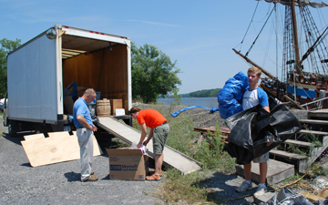Captain Reynolds, Ms. Niehaus, and Mr. Boyle haul gear between the box truck and the ship.
