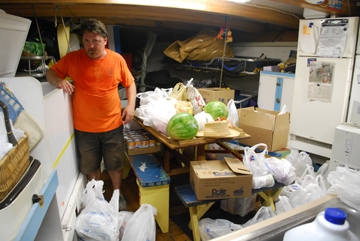 Mr. Wolfe is surrounded by groceries in the galley.