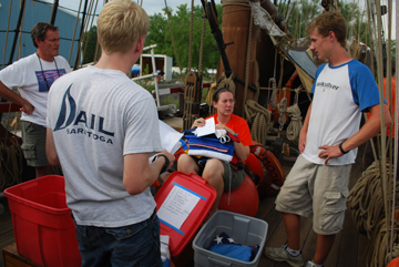Mr. Linehan, Mr. Boudreau, Ms. Niehaus, and Mr. Boyle catalog the ship's flags.