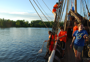 Students climb the rig and stand on the channel while tossing a canvas bucket overboard.