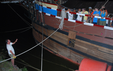Mr. Linehan, on shore, shows the students at the rail how to measure the height of tide.