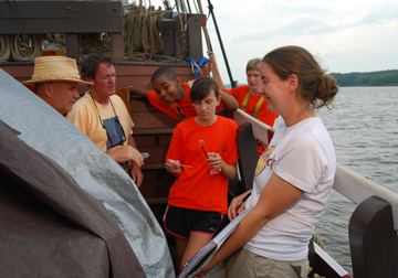 Tahari, Nora, and Alex on set between takes, conferring with video crew.