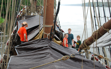 The upper decks are covered in tarps during a rainstorm.