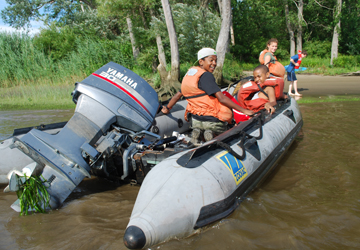 Jason, Tahari, Abby, and Jack land the Zodiak on shore.