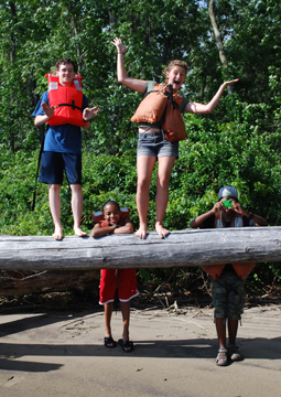 Jack and Abby balance on a log, Tahari relaxes, and Jason takes a photo.