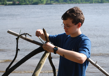 Jack works on the frame for a hut.