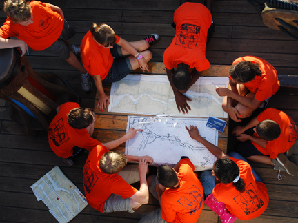 The student crew clusters around historical and modern Hudson River charts.