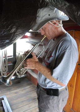 Mr. Weisse plays reveille on his trumpet.