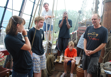 Evi and Deniro play party horns; Alex looks pleased, Nick looks ready to go back to bed.