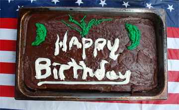 A cake's icing reads "Happy Birthday."