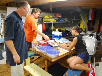 Captain Reynolds looks on as Alanna helps Mr. Wolfe in the galley.