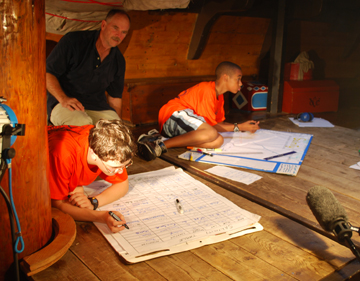 Captain Reynolds directs Jack and Tahari in a scene on the orlop deck.