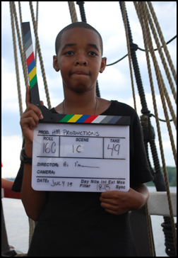 Tahari handles the clapboard for a take.