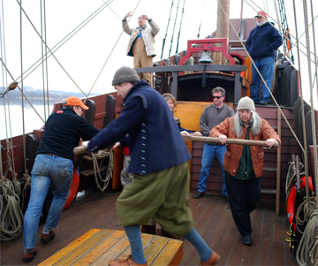 The crew walks the capstan while weighing anchor.