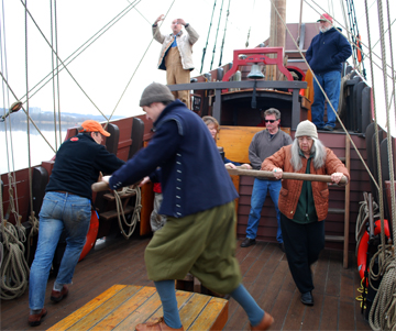 The crew walks the capstan while weighing anchor.