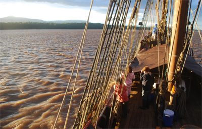 The Half Moon cuts through rippling water at sunset.