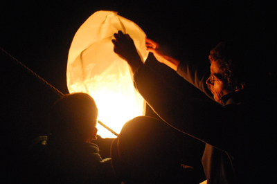 Captain Reynolds, Danielle Stevens, and Robbert Fehmers light a Chinese lantern.