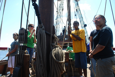 The main mast team sets the main course for the first time.