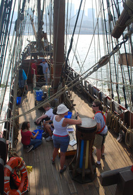 The ship rolls over choppy waves on the East River.