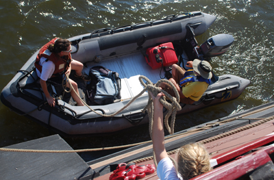 Hayley tosses the painter line down to Ms. Reilly in the Zodiac.