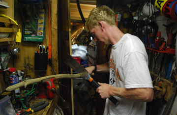 John Boudreau saws driftwood into current markers in the tool alley.