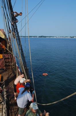 Nick jumps in the water from the main mast shrouds.